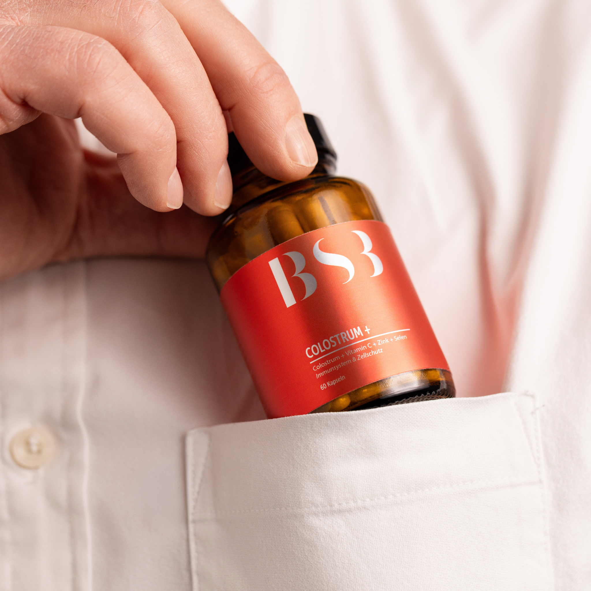 Hautpflegeprodukt COLOSTRUM+ von BeautySystem-3, cremige Textur und weiße Verpackung auf weißem Hintergrund sichtbar